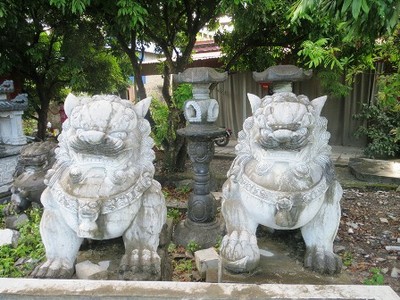 Sư tử đá phong cách châu Âu bị bỏ lăn lóc ngoài bờ bụi.